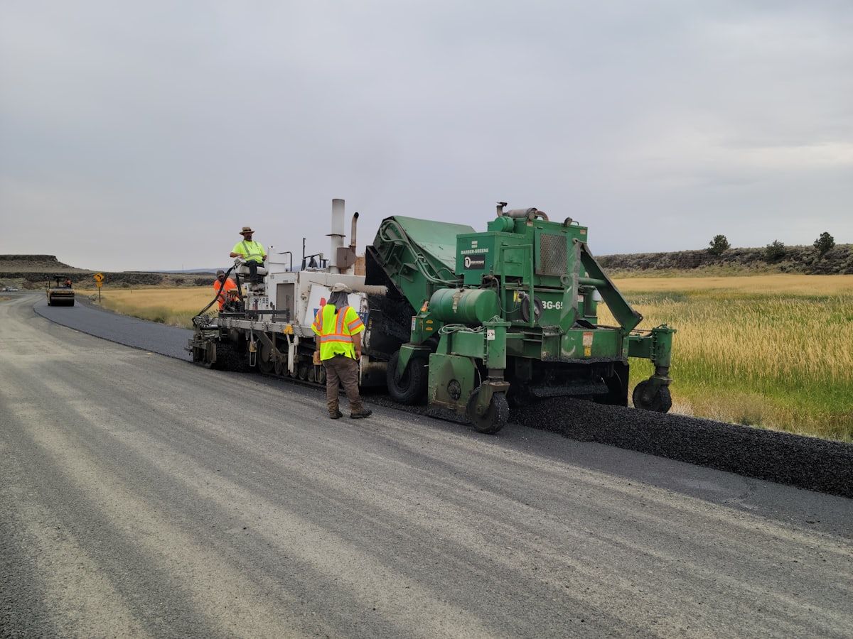 Reference image of a paving crew at work — real photos of Matta Ruiz road and access builds coming soon.